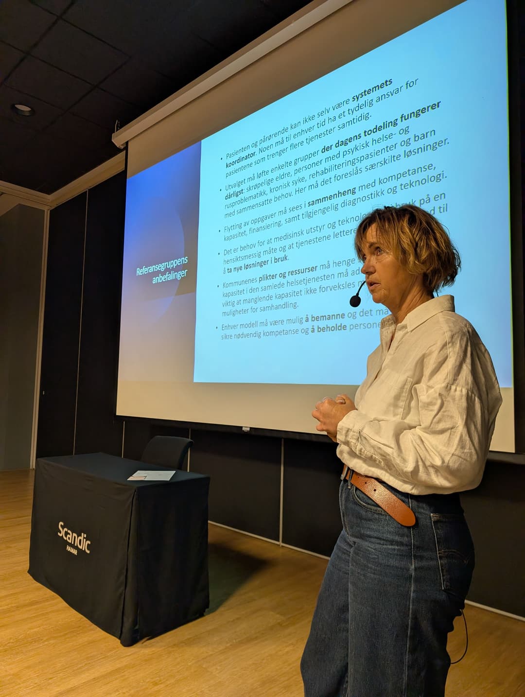 Lilly Ann Elvestad elvestad foran en presentasjon om kommunekommisjonen.