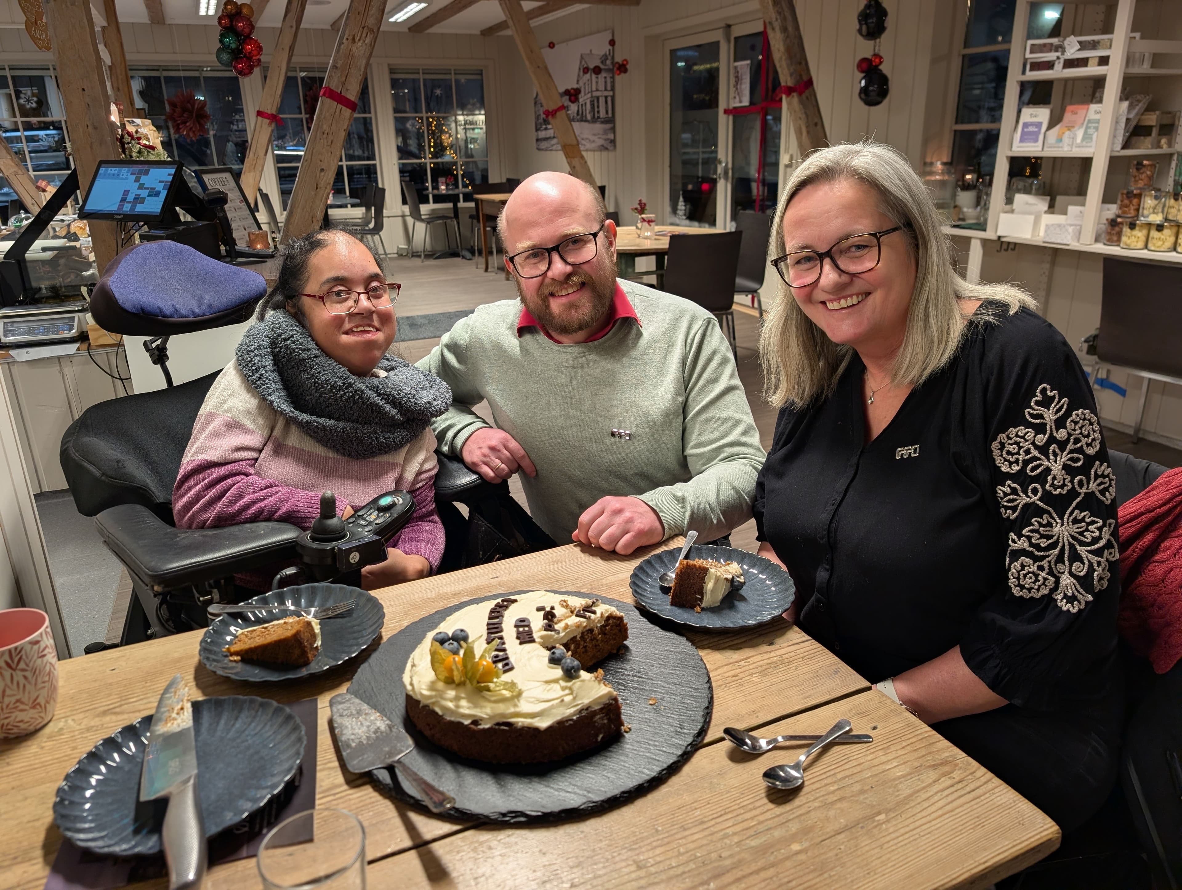 Bilde av tre personer som spiser kake, og feirer at CRPD er vedtatt. Christoffer Biong (FFO), Lina Irene Berg, Grete Nordhagen er avbildet på Østmoe-torget i Elverum. Foran seg har de en kake som det står "Gratulerer med CRPD" på.